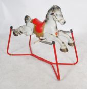 A vintage mid century tin plate child's Prairie King rocking horse by Mobo with red  seat, suspended