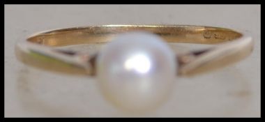 A hallmarked 9ct gold ring set with a single cultured pearl. HallmarkedLondon. Size M. Weight 1.5g.