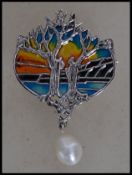 A Silver plique a jour necklace / brooch with glass irridescent back and tress all adorned