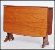 A 1970's teak wood Danish influenced G-Plan drop leaf dining table raised on shaped supports with