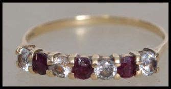 A hallmarked ruby and white stone half eternity ring. Hallmarked London. Size S.