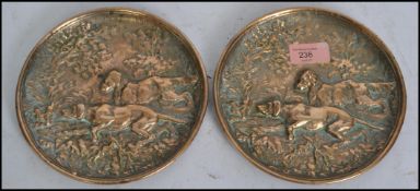 A pair of believed 19th century bronze wall chargers / table plaques of circular form cast in relief