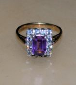 A hallmarked 9ct gold cluster ring with central em