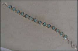 A silver Aquamarine tennis bracelet set with oval cut aquamarines, each stone set in silver