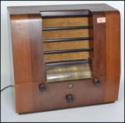 A vintage 20th century Peto Scott wooden cased valve radio. Having a central speaker to the front,