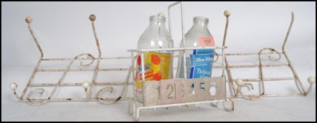 A 1950's milk bottle holder with number slider and 2 advertising bottles to include Crusha Milkshake
