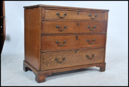 A Georgian oak bachelors chest of drawers being raised on bracket feet having a series of graduating