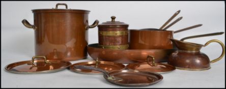 A collection of vintage copper saucepans some lidded, skillet pan together with a brass storage tin.