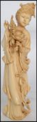 A Late 19th Early 20th Century Chinese Carved Ivory Figure in the form of a girl holding flowers.
