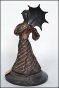 A good early 20th century cold painted bronze figurine of a lady with parasol being set to a socle