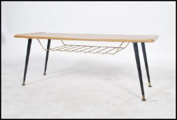 A vintage mid 20th century long john coffee table raised on splayed tapered legs united by a mesh