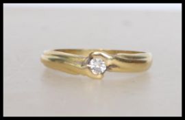 An 18ct gold ( Tested ) solitaire diamond cross over ring having a single mounted stone. Total