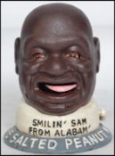 A vintage style cast iron advertising point of sale money bank in the form of Smiling Sam The Salted