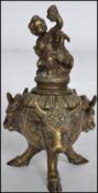 A 19th century stunning brass inkwell having rams head masks to each side of the cauldron shaped