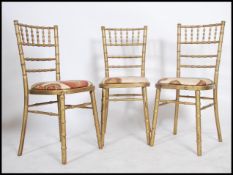 A set of 4 20th century gilt bamboo dining chairs. The chairs with chintz upholstered pad seats