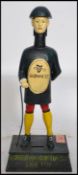 A vintage style advertising point of sale money bank figurine of a Guinness man raised on a plinth