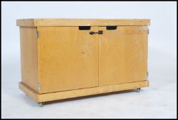A 20th century Industrial beech wood school cupboard on wheels. Raised on castors with plinth base