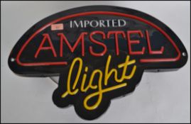 A retro  20th century neon style Amstel Beer advertising light box sign havin faux neon style front.