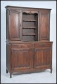 A 19th century French provincial oak dresser being raised on shaped legs with deep cupboards