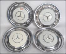 A set of four vintage / retro 1970's wheel cover hub caps from a Mercedes. The covers having a