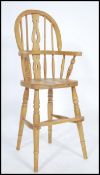 A Victorian style country pine childs high chair raised on turned legs united by stretchers having