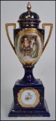 A 19th century Continental twin handled ceramic lidded urn, on cobalt blue ground with central panel