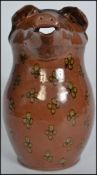 A Peter Arnold Studio pottery glazed jug with pigs head pourer. The main body with dimpled yellow