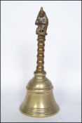 A large 18th / 19th century cast brass bell of tall form with twist handle and adorned with mythical