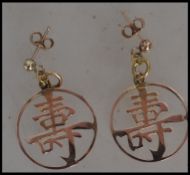 A pair of 14ct gold drop earrings having oriental symbols with post backs. Total weight 2.8g. Marked