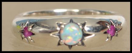 A silver ladies 20th century gypsy ring having inset opal and garnet stones within star settings.