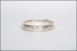 A silver hallmarked bangle with engraved foliate design, Birmingham assay mark dating to 1986