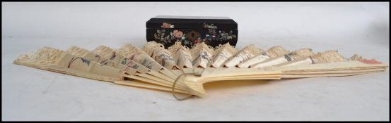 A vintage early 20th century ladies hand fan of bone construction depicting birds and trees along