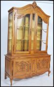 A large French 20th century oak vitrine display cabinet. Raised on shaped cabriole legs with cabinet