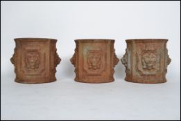 A set of 3 19th century cast iron cylindrical plant pots / planters each with lion mask decoration