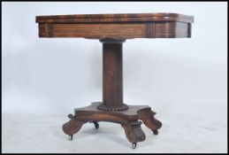 A Regency early 19th century rosewood games / card table being raised on a quadruped base with
