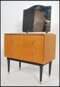 A 1960's retro natural oak style dressing chest of drawers. Raised on tapering legs with a bank of
