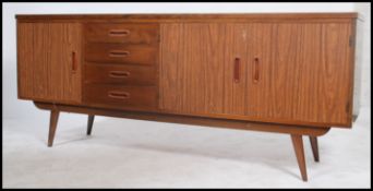 A retro 20th century teak wood sideboard consisting of a series of drawers and cupboards raised on