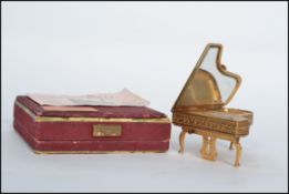 A vintage mid 20th century Pygmalion Piano musical  Powder compact, with fold down legs, original