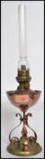A early 20th century Arts and Craft movement copper and brass oil lamp having a scroll work tripod