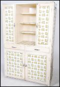 A large mid century retro painted pine kitchen dresser cabinet having applied chintz wall paper