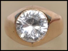 A 9ct gold and white stone ring having a single a round cut white stone in a bezel setting. Marked