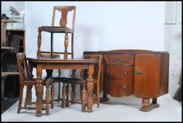 An early to mid 20th century oak dining suite to include a draw leaf table with a set of four