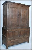 An 18th / 19th century oak armoire wardrobe having twin fielded panel doors over a panelled front