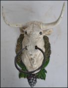 A vintage style cast iron cows /  bull head mounted on a naturalistic wreath armorial shield