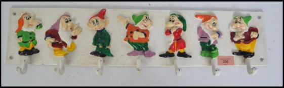 A vintage style cast iron Snow White Disney style coat rack. Each dwarf being hand painted with hook