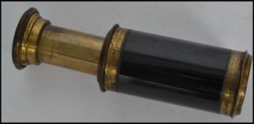 A miniature early 20th century 3 draw pocket brass telescope having ebonised detailing. Measures:
