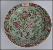 A 19th century Chinese celadon charger / dish, decorated in famille rose colours with butterflies