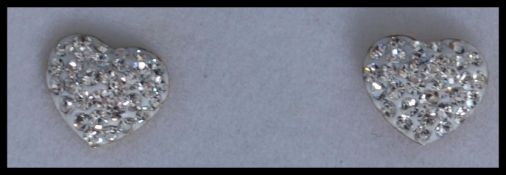 A pair of 9ct gold earrings in the form of hearts with pave set crystals and post backs. Marked