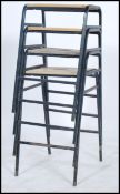 A set of four vintage retro British elm topped school science lab stools raised on tubular