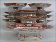 A 20th century handpainted Chinese / Asiatic tazza dinner service - tazza plates, each raised on